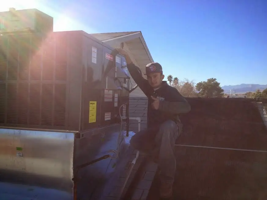 HVAC technician performing Heat Pump Repair on a rooftop unit in La Puente